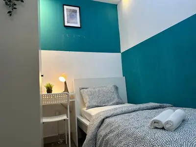 a blue and white bedroom with a bed and a chair at Epic Partition Room in Barsha Near Metro in Dubai