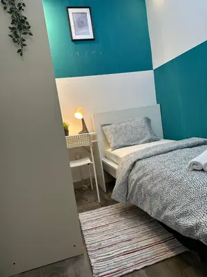 a small bedroom with a bed and a desk at Epic Partition Room in Barsha Near Metro in Dubai