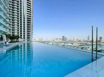 a large swimming pool with a view of the city at Seaside Serenity Perfect Beachfront Holiday Haven in Dubai