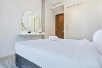 a white bedroom with a mirror and a bed at STAY BY LATINEM Luxury 1BR Holiday Home CVR B2704 near Burj Khalifa in Dubai