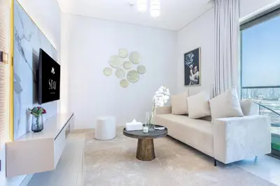 a living room with a couch and a table at STAY BY LATINEM Luxury 1BR Holiday Home CVR B2704 near Burj Khalifa in Dubai