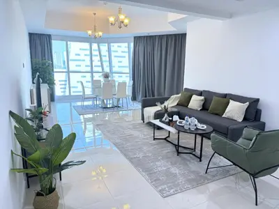 a living room with a couch and a table at Deluxe Apartment With Panoramic View Near Metro in Dubai