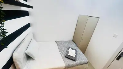 a small bedroom with a bed with a paper on it at Fashion Partition Room Near Mall of The Emirates in Dubai