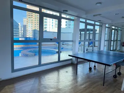 a ping pong table in the middle of a room with windows at Stay in heart of Dubai Marina Residence B walk to the JBR in Dubai