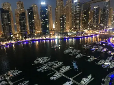 a group of boats docked in a harbor at night at Stay in heart of Dubai Marina Residence B walk to the JBR in Dubai