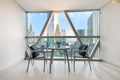 a table and two chairs in a room with a large window at Difc 1 Bd apartment in Park Tower in Dubai