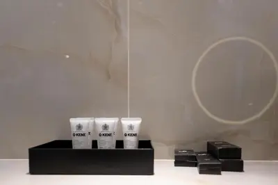 a group of four white cups and a mirror at Lux BnB Princess Tower Palm Ocean Views in Dubai
