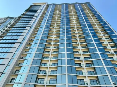 a tall apartment building with blue sky in the background at Stylish brand new 1 bedroom in Dubai
