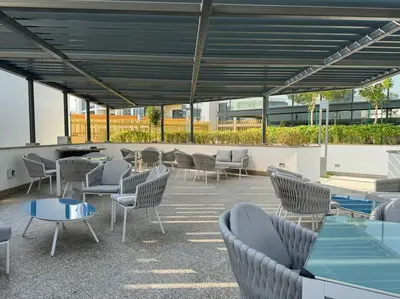 a group of chairs and tables in a patio at Stylish brand new 1 bedroom in Dubai