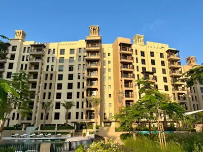 a large building with palm trees in front of it at Brand new 2 Bedroom apartment in Madinat Jumeirah Living in Dubai