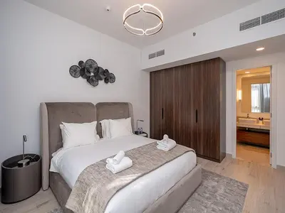 a bedroom with a large bed with two white towels on it at Brand new 2 Bedroom apartment in Madinat Jumeirah Living in Dubai