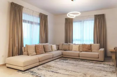 a white couch in a living room with windows at New 2 bedroom entire apartment in Madinat Jumeirah Living in Dubai
