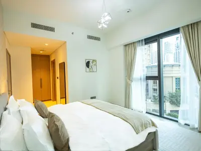 a bedroom with a large bed and a large window at MH - Act One Act Two - 2BHK - REF503 in Dubai