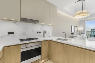 a white kitchen with a sink and a stove at EDEN'S Homes & Villas - Address Opera District Residences in Dubai