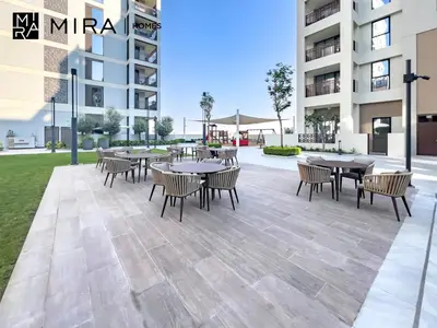 a patio with tables and chairs in front of a building at Mira Holiday Homes - Fully furnished 1 bedroom in Creek Harbour in Dubai