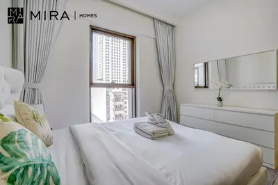 a white bedroom with a bed and a window at Mira Holiday Homes - Fully furnished 1 bedroom in Creek Harbour in Dubai