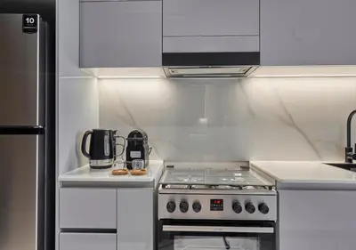 a kitchen with a stove and a microwave at Lux Studio in Business Bay -10 mins to Burj Khalifa - Binghatti Canal in Dubai