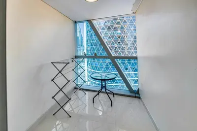 a stool in front of a window in a room at Bright studio in DIFC near the metro station in Dubai
