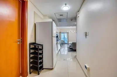 a hallway with a white refrigerator in a room at Bright studio in DIFC near the metro station in Dubai