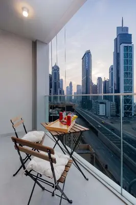 a table and chairs on a balcony with a view of the city at 2-Bedroom in the Heart of Downtown Dubai in Dubai