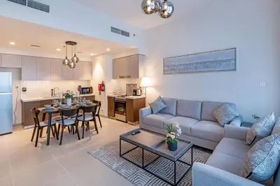 a living room with a couch and a table and a kitchen at 2-Bedroom in the Heart of Downtown Dubai in Dubai