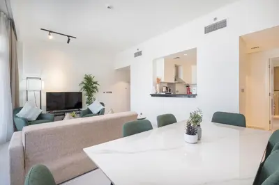a living room with a couch and a table and chairs at Stylish Stayz beautiful modern apartment with Burj Khalifa views in Dubai