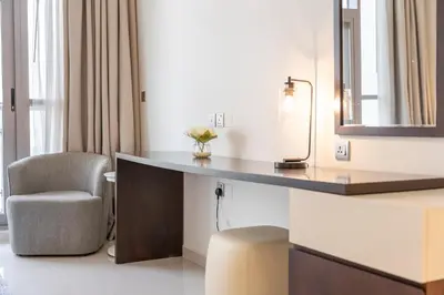a hotel room with a desk and a chair at Stylish Stayz beautiful modern apartment with Burj Khalifa views in Dubai