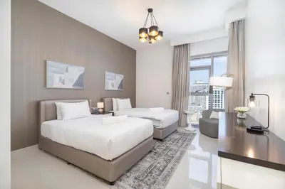 a bedroom with two beds and a living room at Stylish Stayz beautiful modern apartment with Burj Khalifa views in Dubai