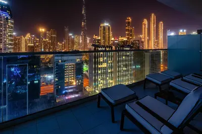 a balcony with a view of a city at night at Luxury Top Floor apt with Full Burj Khalifa view in Dubai
