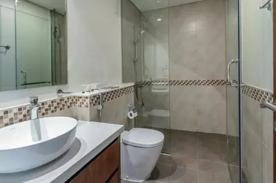 a bathroom with a sink and a toilet and a shower at Stylish Stayz 2BR Corner Unit - Yacht & Burj Khalifa Views - close to Dubai Mall in Dubai