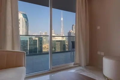 a bedroom with a large window with a view of a city at Stylish high floor apartment with Burj View in Dubai