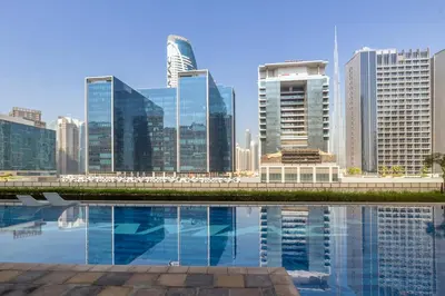 a city skyline with a pool of water with buildings at Stylish high floor apartment with Burj View in Dubai