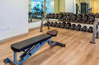 a gym with a bench and lots of exercise equipment at Stylish Apartment 5 minutes from Dubai Mall with canal view in Dubai