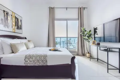a bedroom with a bed and a large window at Frank Porter - Elite 5 Sports Residence in Dubai
