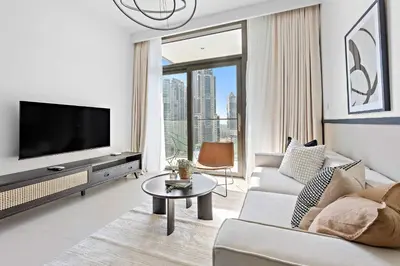 a living room with a couch and a tv at Silkhaus Upscale 1BR by Burj Khalifa with Balcony in Dubai