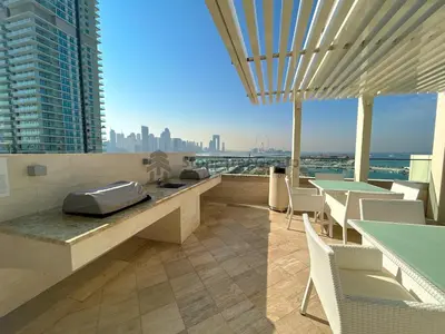 a restaurant with tables and chairs and a view of the city at StoneTree - New Luxury Apartment with Private Beach in Dubai