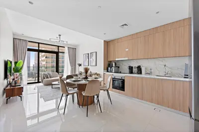 a kitchen and living room with a table and chairs at StoneTree - New Luxury Apartment with Private Beach in Dubai