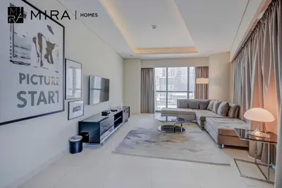 a living room with a couch and a tv at Mira Holiday Homes - Furnished 1 bedroom in Paramount Tower B in Dubai