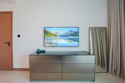 a tv on top of a dresser in a room at NEW Luxe 3BR in Vida Marina w/ Breathtaking Views in Dubai