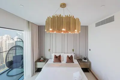 a bedroom with a bed and a chandelier at NEW Luxe 3BR in Vida Marina w/ Breathtaking Views in Dubai