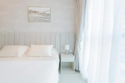 a white bedroom with a bed and a window at Luxury Studio, Seven Palm Residence-Palm Jumeirah in Dubai