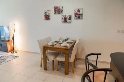 a dining room with a wooden table and white chairs at Stunning 1 BR Apartment in Dubai Marina in Dubai
