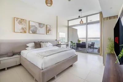 a bedroom with a large bed and a balcony at GuestReady - Glamourous living in Palm Jumeirah in Dubai