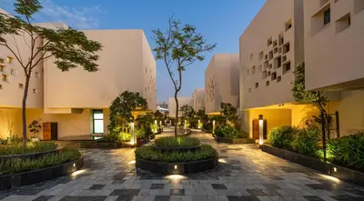 a courtyard of a building with trees and plants at The Biltmore Hotel Villas, Dubai in Dubai