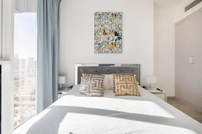 a bedroom with a large white bed with two pillows at Dubai Dreamland 1BR for 4, King Bed, Pool, Sauna, Gym, Free Parking in Dubai