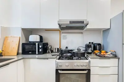 a kitchen with two pots and pans on a stove at Dubai Dreamland 1BR for 4, King Bed, Pool, Sauna, Gym, Free Parking in Dubai