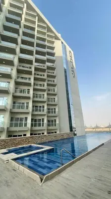 a large building with a swimming pool in front of it at Best Offer in Dubai hotel apartment damac hills 2 in Dubai