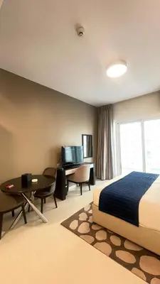 a bedroom with a bed and a desk and a table at Best Offer in Dubai hotel apartment damac hills 2 in Dubai