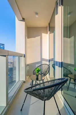a balcony with a table and chairs on a building at Modern 1 BR with Sea View - Minutes to Dubai Mall, Downtown Dubai in Dubai