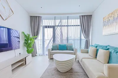 a living room with a couch and a tv at Modern Fully-Equipped Apartment in Seven Palm, Beach and Pool Access in Dubai